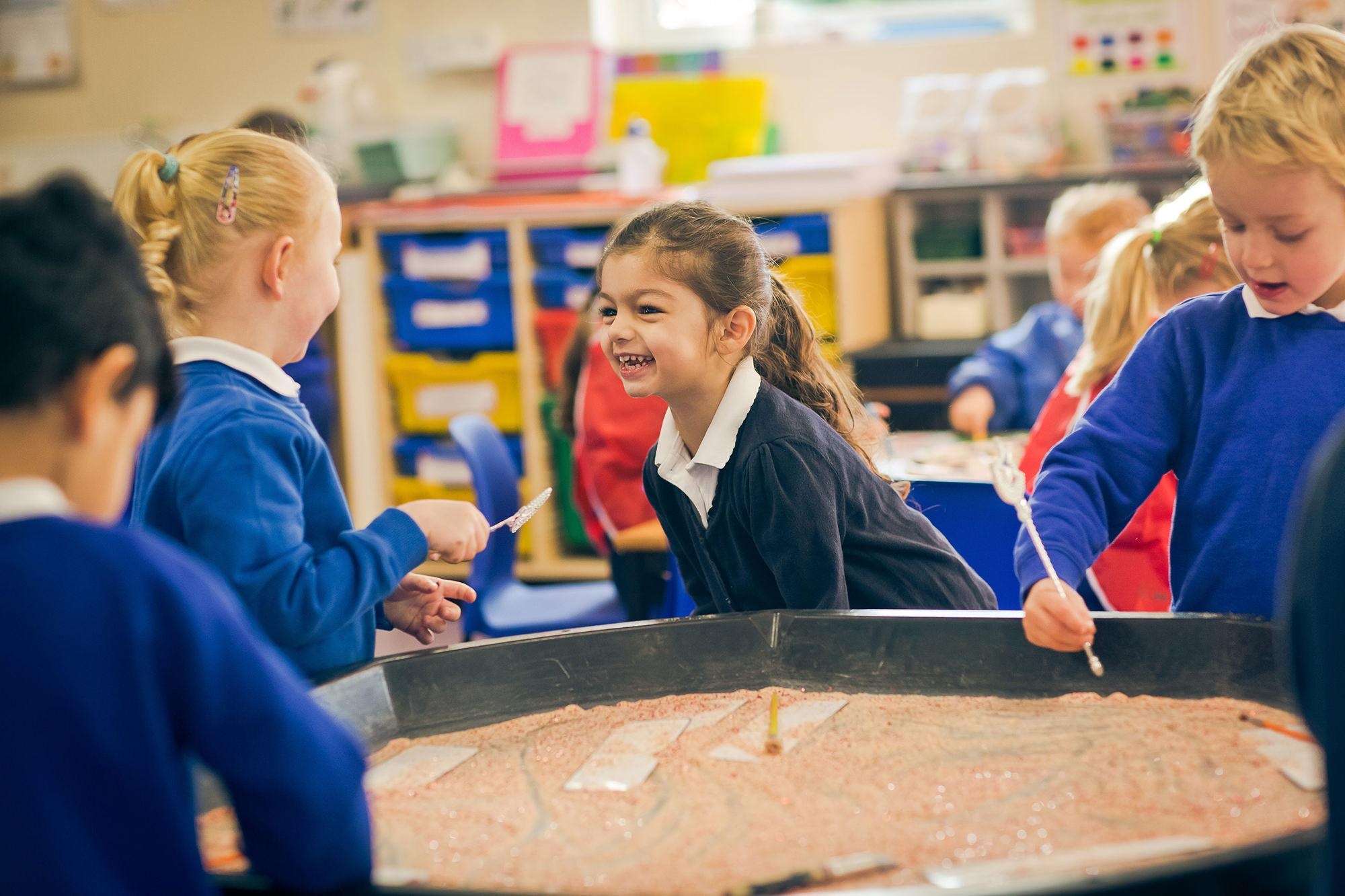 Children around Sandpit smiling